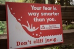 Photo of a red warning sign to prevent cliff jumping